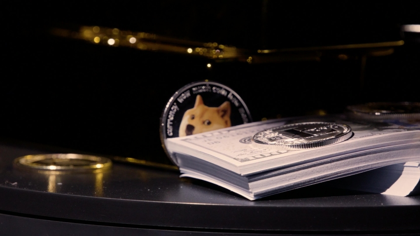 Close up gold bars, cryptocurrency and stacks of one hundred dollar bills rotating through light smoke in slow motion