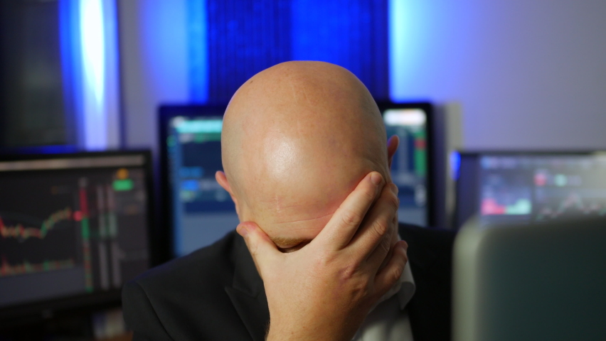 A depressed stock trader shaking his head after losing money on the forex crypto exchange after a market crash | Shutterstock HD Video #1095269721