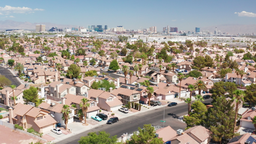 Aerial shot of Las Vegas residential homes next to airport with city skyline Royalty-Free Stock Footage #1095271073