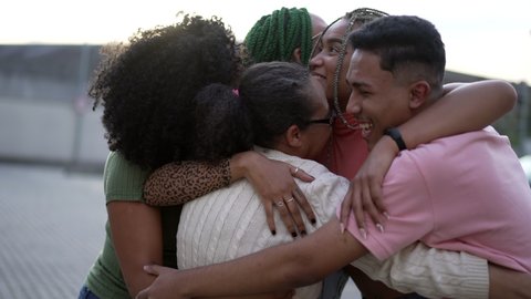 A black family embrace. Group of South American hispanic people hugging each other outdoors. Portrait of happy friends embracing. Friendship concept स्टॉक वीडियो