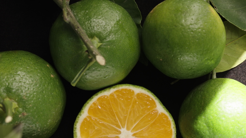 Half of a tangerine top view, green peel. Dolly slider extreme close-up. Royalty-Free Stock Footage #1095285129