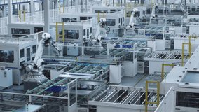 Time-lapse video of Large Solar Panel Automated Production Line with Industrial Robot Arms. Looped video. Modern, Bright Manufacturing Facility.