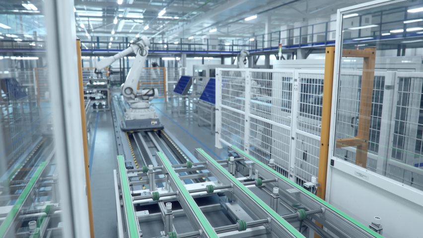 White Industrial Robot Arm at Production Line at Modern Bright Factory. Solar Panels are being Assembled on Conveyor. Automated Manufacturing Facility Royalty-Free Stock Footage #1095285291
