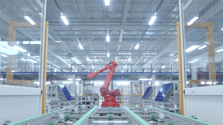 Orange Industrial Robot Arm Moving Solar Panels at Production Line at Modern Bright Factory. Solar Panels are being Assembled on Conveyor. Automated Manufacturing Facility. POV view from the Line Royalty-Free Stock Footage #1095285293