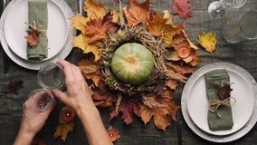 Woman set table for Thanksgiving dinner. Autumnal table setting for festive feast. Top view. - Powered by Shutterstock - Get 15% off with code: PIKWIZARD15