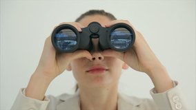 Tilt up image of young businesswoman using binoculars. Female professional is searching for opportunities. Executive is standing against wall. - Powered by Shutterstock - Get 15% off with code: PIKWIZARD15