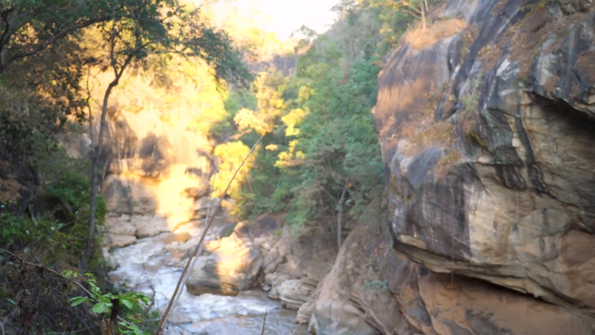 Happy traveler with backpack celebrate reaching of goal raising arms, found secret pathway. Young man travel in mountains, finish track, happily raise hands, rejoice success. Active lifestyle concept.