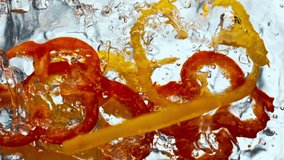 Fresh juicy pepper fall clean liquid in super slow motion. Red yellow tasty paprika splashing transparent water on white background close up. Vitamin organic food for healthy active lifestyle.  - Powered by Shutterstock - Get 15% off with code: PIKWIZARD15
