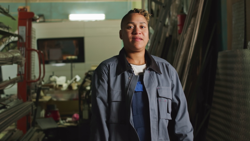 Medium portrait of Biracial female mechanic posing with hands folded at factory | Shutterstock HD Video #1095304191