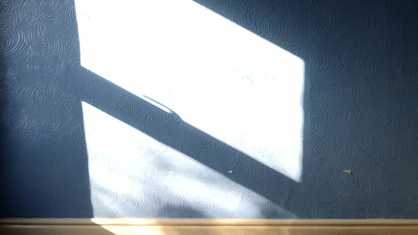 A dark shadow of a man looking through a window with the sun coming through the window on a bedroom wall, intruder burglar or murder mystery concept. Royalty-Free Stock Footage #1095304463