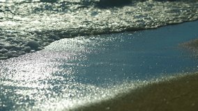 Beautiful video of sea waves splshing on the beach sand at sunset
