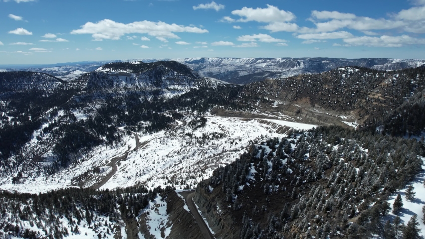 Aerial View of Mountain Peaks and Scenic Road Route in White Winter Landscape, Douglas Pass, Colorado USA