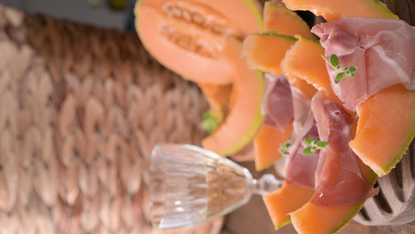 Italian prosciutto crudo with melons. Slices of traditional ham wrapped around melons. Tasty appetizer. Food background. Close up. Snack for wine for an aperitif