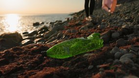 Conservation of ecology and Earth Day. A volunteer walking down the beach and pick up plastic bottle. Coastal cleanup for recycling. World environment day and pollution of ocean concept. - Powered by Shutterstock - Get 15% off with code: PIKWIZARD15