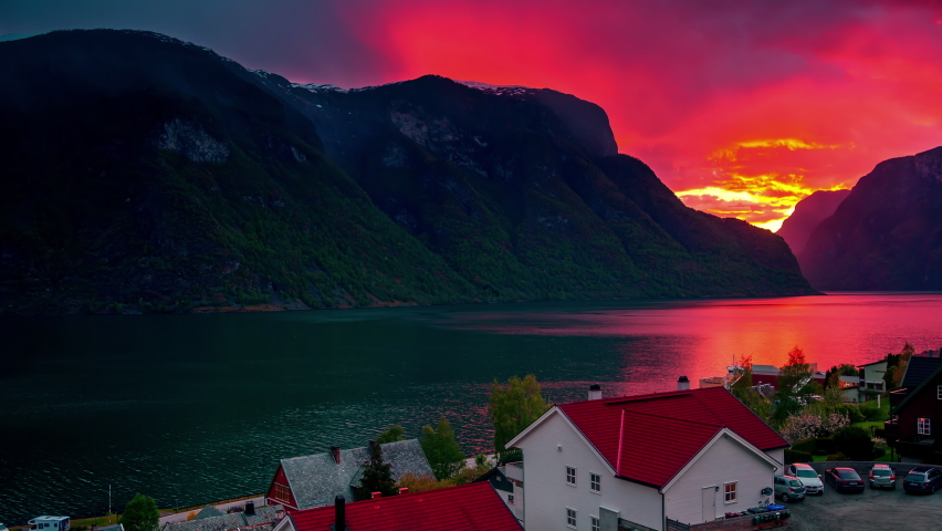 Breathtaking sunset In Norway fjord landscape, Dark clouds crossing the Red Sky, Time Lapse