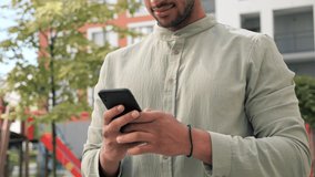 Closeup joyful african american man reading good news on phone in slow motion. Overjoyed male freelancer holding black mobile phone celebrate online win success, read great news using smartphone.
