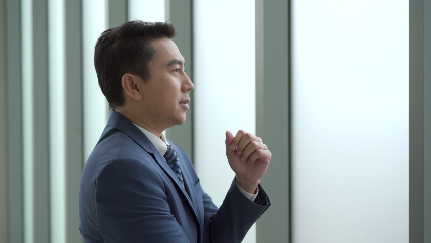 Smart and good looking Asian businessman looking at the camera and crossed arms. Photograph with copyspace.