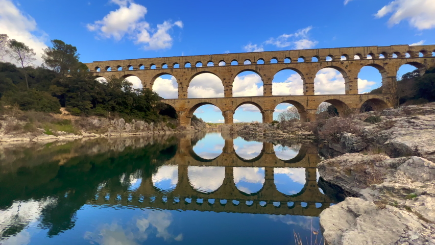 Sublime view of Pont du Gard from the river, an ancient Roman aqueduct bridge, Vers-Pont-du-Gard, Ssuthern France. Built in the first century AD to carry water to the Roman colony of Nemausus (Nîmes)
