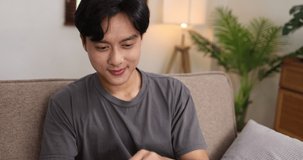 Young asian man using digital tablet computer and relaxing at home, happy young man online work concept.