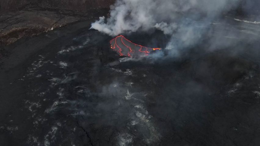 Flying above the crater of Kilauea volcano with an active volcanic eruption of lava flows and smoke. Big Island, Hawaii Volcanoes National Park Royalty-Free Stock Footage #1095352557