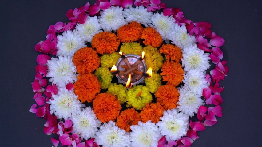 Happy Diwali. Traditional symbols of Indian festival of light. Burning diya oil lamps and flowers on red background. Copy space.