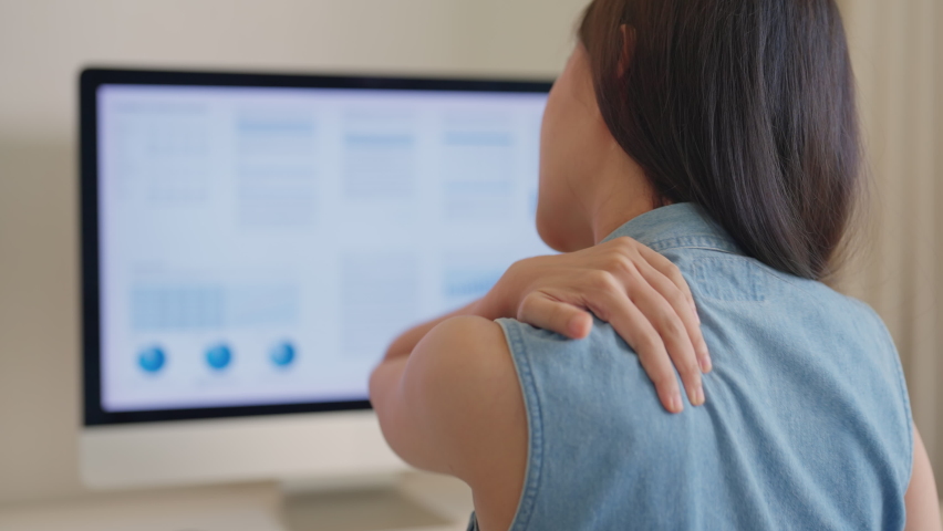 Back view of young adult Gen Z asia female busy remote job work hard bored tired stiff neck relief pain ache sit bad posture on desk computer in chronic suffer mental burnout syndrome at home office. Royalty-Free Stock Footage #1095359325