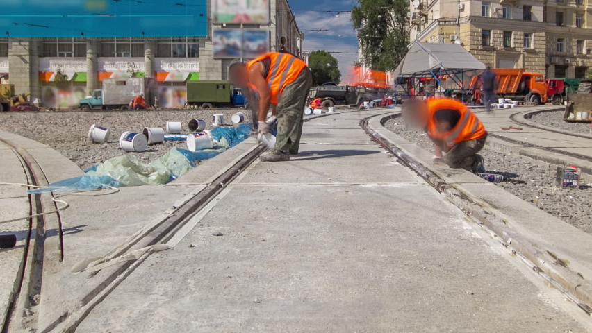 Tram rails at the final stage of their installation and integration into concrete plates on the road panoramic timelapse. Filling by liquid resin for reduction of vibration and noice. The process of