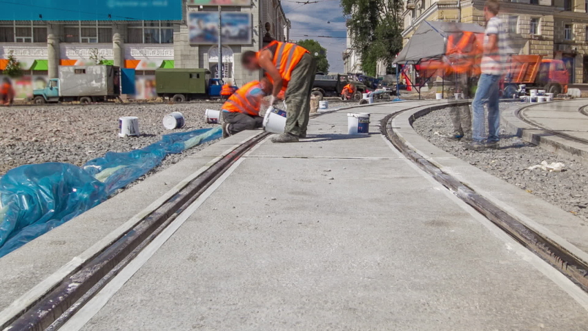 Tram rails at the final stage of their installation and integration into concrete plates on the road panoramic timelapse. Filling by liquid resin for reduction of vibration and noice. The process of