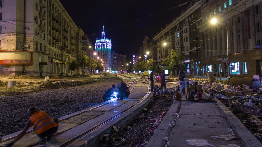 Tram rails at the final stage of their installation and integration into concrete plates on the road night timelapse in the city. Filling by liquid resin for reduction of vibration and noice. The