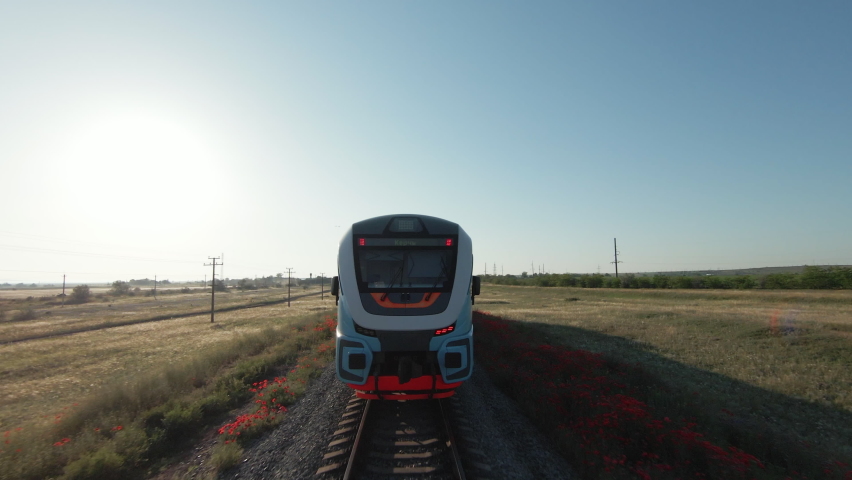 Summer landscape with high-speed train. Shot. A new train moving fast on rails around grass and empty fields. Royalty-Free Stock Footage #1095361693