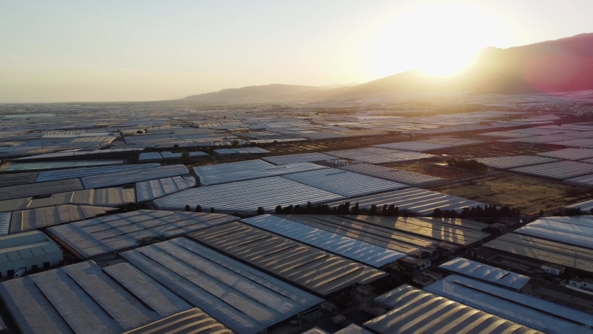 Aerial shot of sunset over greenhouses in industrial agricultural area in Almeria, Spain.  Royalty-Free Stock Footage #1095361821