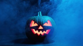 Halloween pumpkin glowing inside in the dark. Scary Pumpkin with smoke around it. Pumpkin glows on Halloween night. Close-up in 4K, UHD - Powered by Shutterstock - Get 15% off with code: PIKWIZARD15