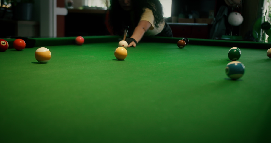 Sinking yellow ball number one into a pocket.Sports game of billiards on a green cloth. Billiard balls with numbers on a pool table. Billiards team sport. | Shutterstock HD Video #1095371965