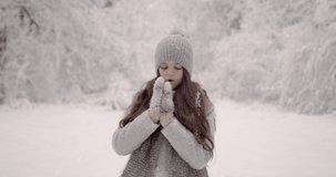 Cute little girl in mittens holding a snowball