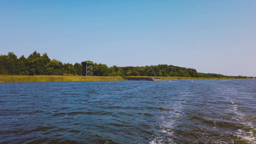 Polish national flag on boat. Cruising on Lebsko Lake at Slowinski National Park. Poland | Shutterstock HD Video #1095375353