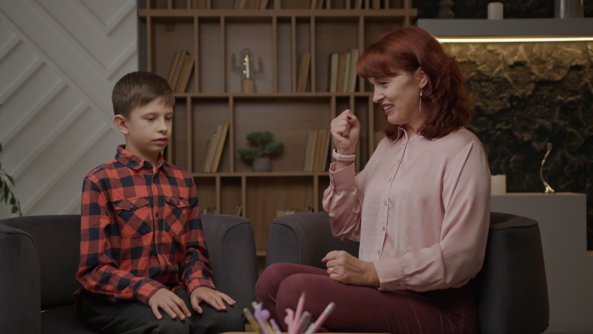 Autistic kid playing game with therapist. School boy with autism studying with tutor. Autistic child learns to focus attention and coordination. Royalty-Free Stock Footage #1095375847
