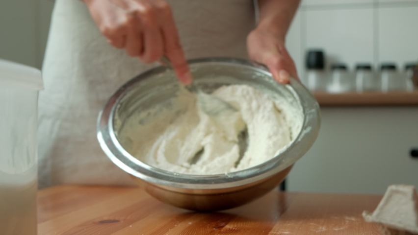 cook mixes cottage cheese with egg and sugar. the chef prepares the dough. chef preparing cheesecake. hands stir the dough in an iron plate Royalty-Free Stock Footage #1095378617