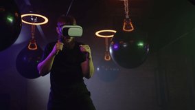 Virtual boxing. Professional strong man is wearing futuristic vr glasses with latest innovative technology augmented reality holograms to practice shadow boxing. People, sport and technology concept