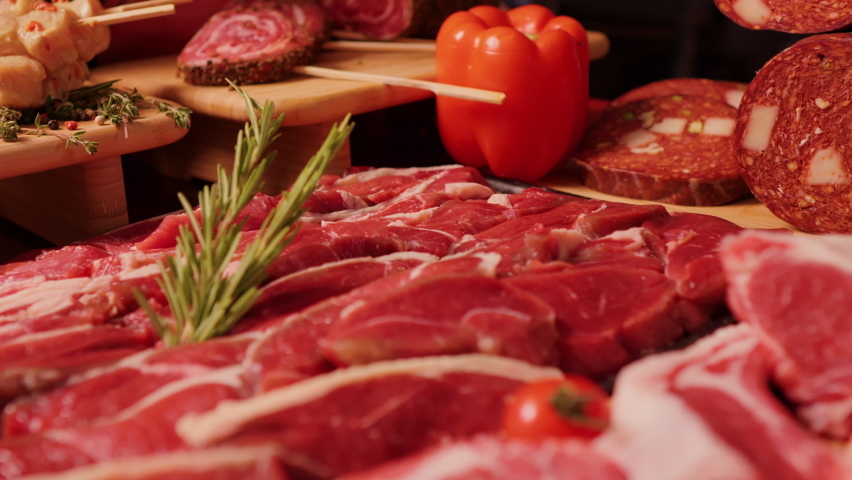 Close up delicious meat table layout raw steaks and sausages. Premium organic meat to sell in market. Meat industry concept. | Shutterstock HD Video #1095381575