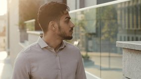 Portrait male man guy businessman employer thinking walks street looking at windows of city building. Hispanic bearded pensive entrepreneur walking outdoors thinks looking to side Latina tourist going