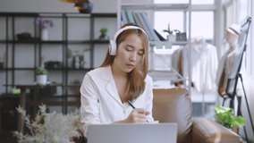 Young Asian business woman using laptop online meeting in video call conference in living room at home.