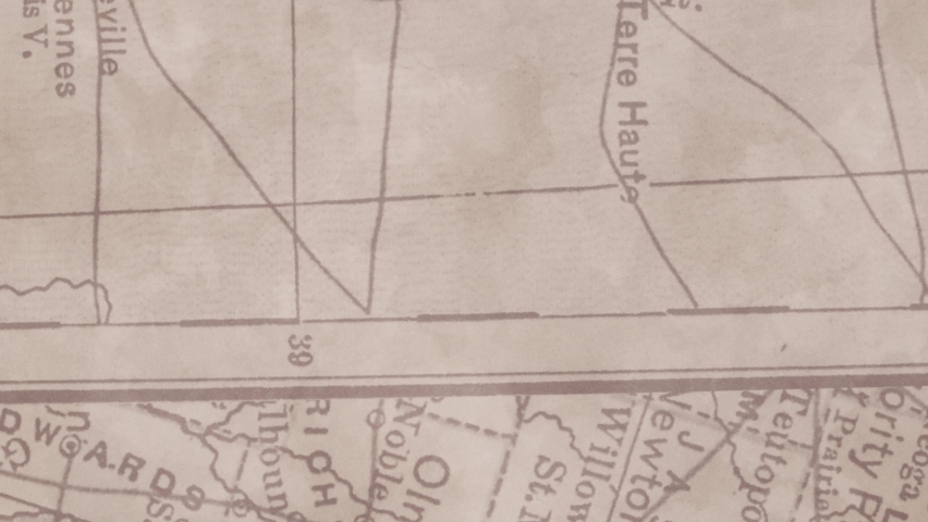 A black car circulates from left to right of the scene on a map. Stop motion animation.