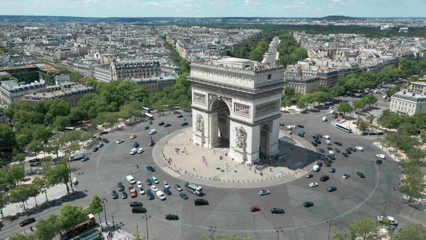 Triumphal arch and car traffic on roundabout with Paris cityscape, France. Aerial orbiting Royalty-Free Stock Footage #1095392793