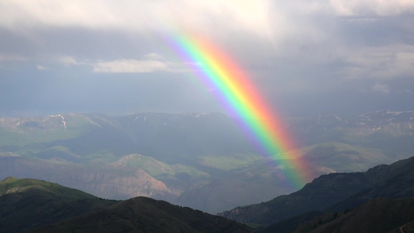 right colorful rainbow in the deep valley in the mountains.Cinematic 4K.Rainbow optical meteorological phenomenon reflection. Royalty-Free Stock Footage #1095397243