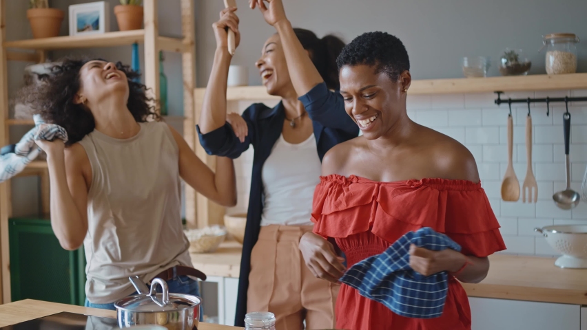 Beautiful young women spending time together and having fun.  girls lifestyle moments in the kitchen while cooking. Representation of happy friends laughing and sharing good vibes | Shutterstock HD Video #1095399179