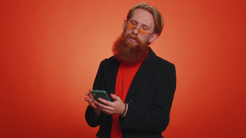Handsome tourist young man using smartphone typing new post on web, browsing, searching, addiction of social networks, show thumbs up like, positive feedback, recommends wifi cellular connection 5G
