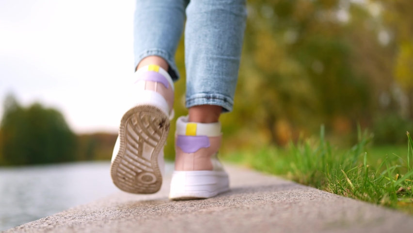 girl walking along the promenade under an umbrella.