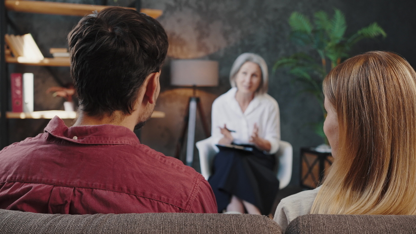 Man and woman sort things out after talking to experienced family psychologist. Couple happy after visiting psychotherapist for relationship counseling at office | Shutterstock HD Video #1095402925