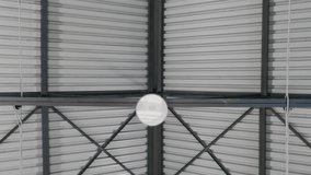 Video. Type of lighting shades and metal ceilings of roof of industrial hangar or warehouse from inside. Smooth video from top to bottom. Production of modern metal structures..