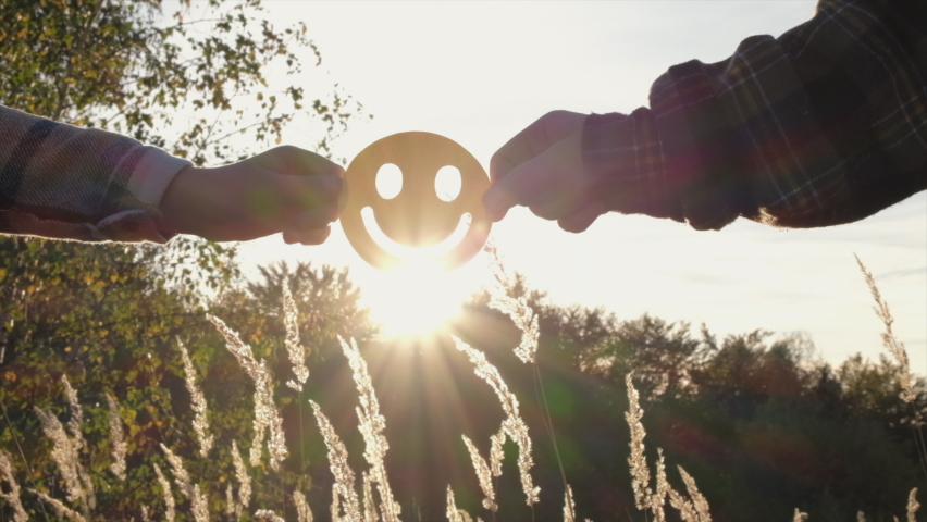 Close up of mother and daughter holding happy face emoticon on background amazing sunset or sunrise at autumn day. Positive picture or cheerful life, World mental health day and eco-friendly concept | Shutterstock HD Video #1095403969